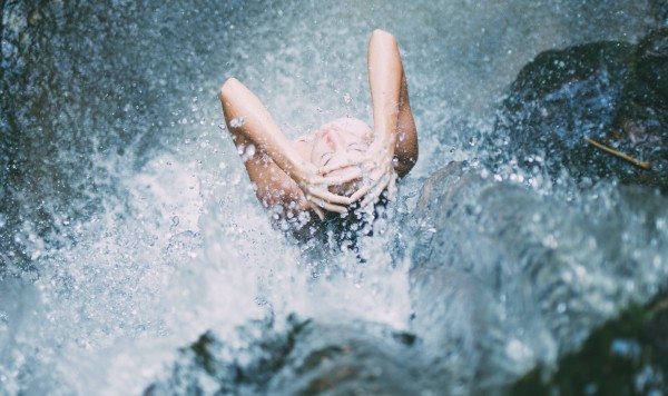 woman washing at waterfall