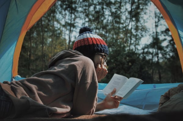 person reading in a tent